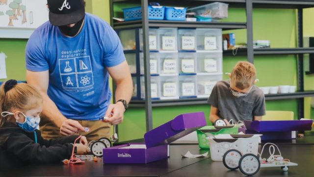 two youth with Actua program leader learning STEM