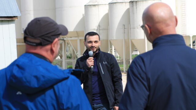 Mohammad Asefi presenting in front of grain bins